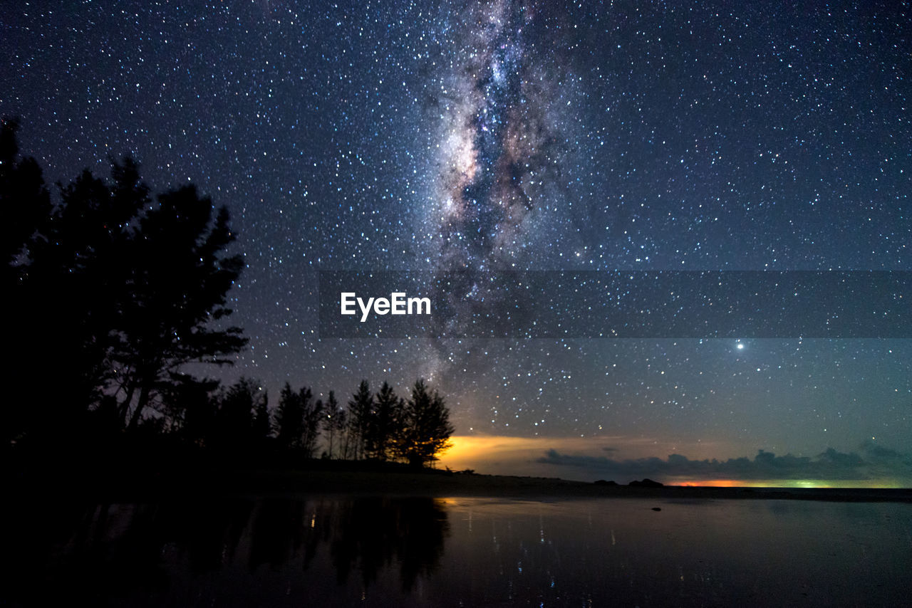 Scenic view of lake against sky at night