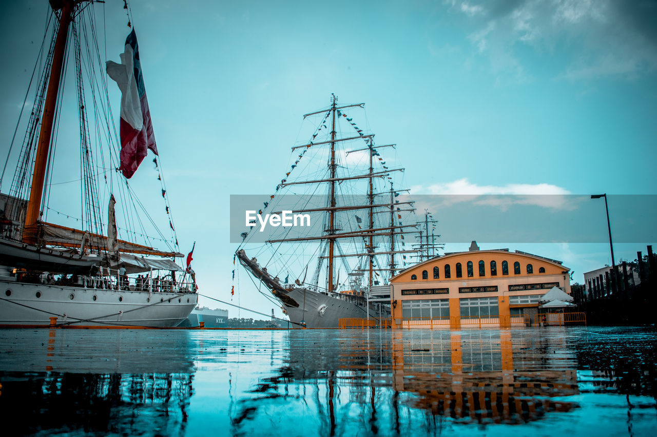 Sailboats moored at harbor