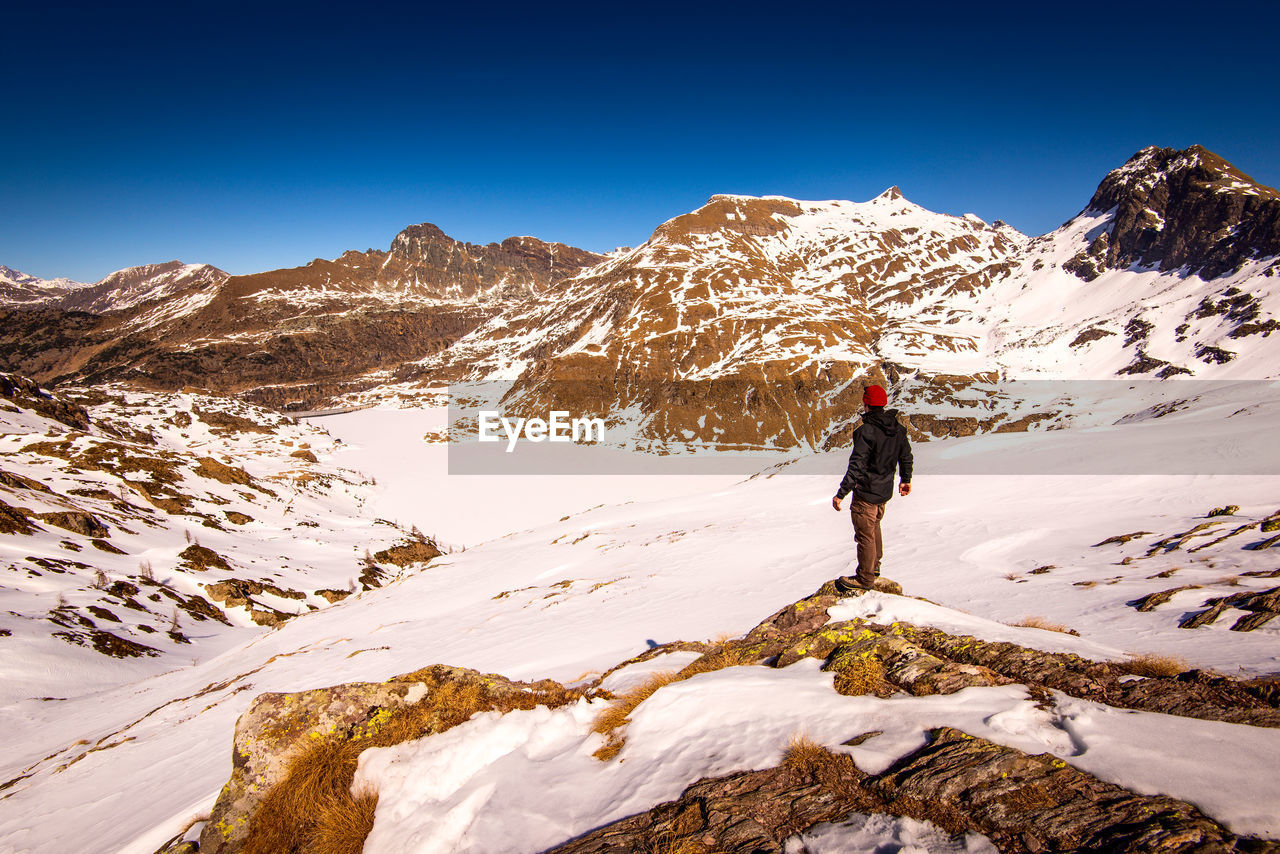 Man hiker contemplate the landscape in mountain time to disconnect concept and healthy lifestyle