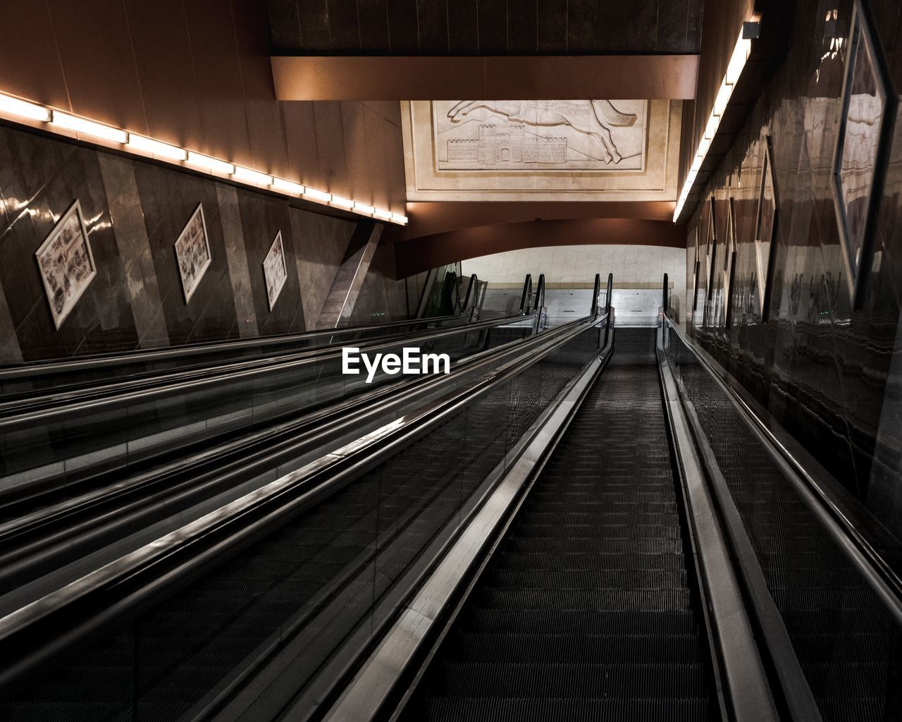 Interior of illuminated escalator stairs in a subway station