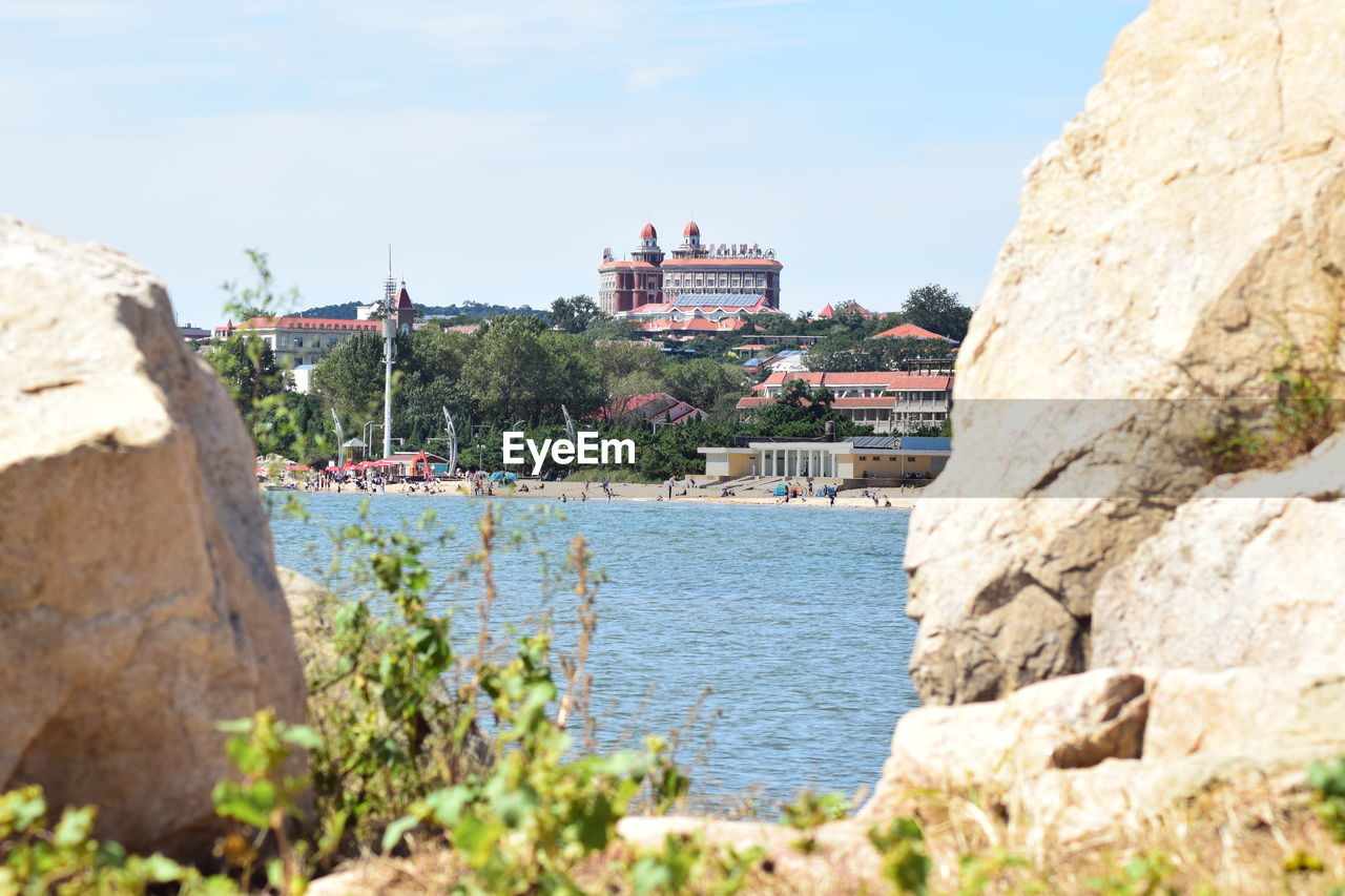 Scenic view of sea by buildings against sky