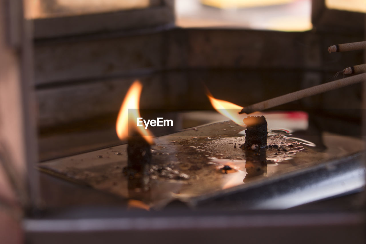 Close-up of burning candles at temple