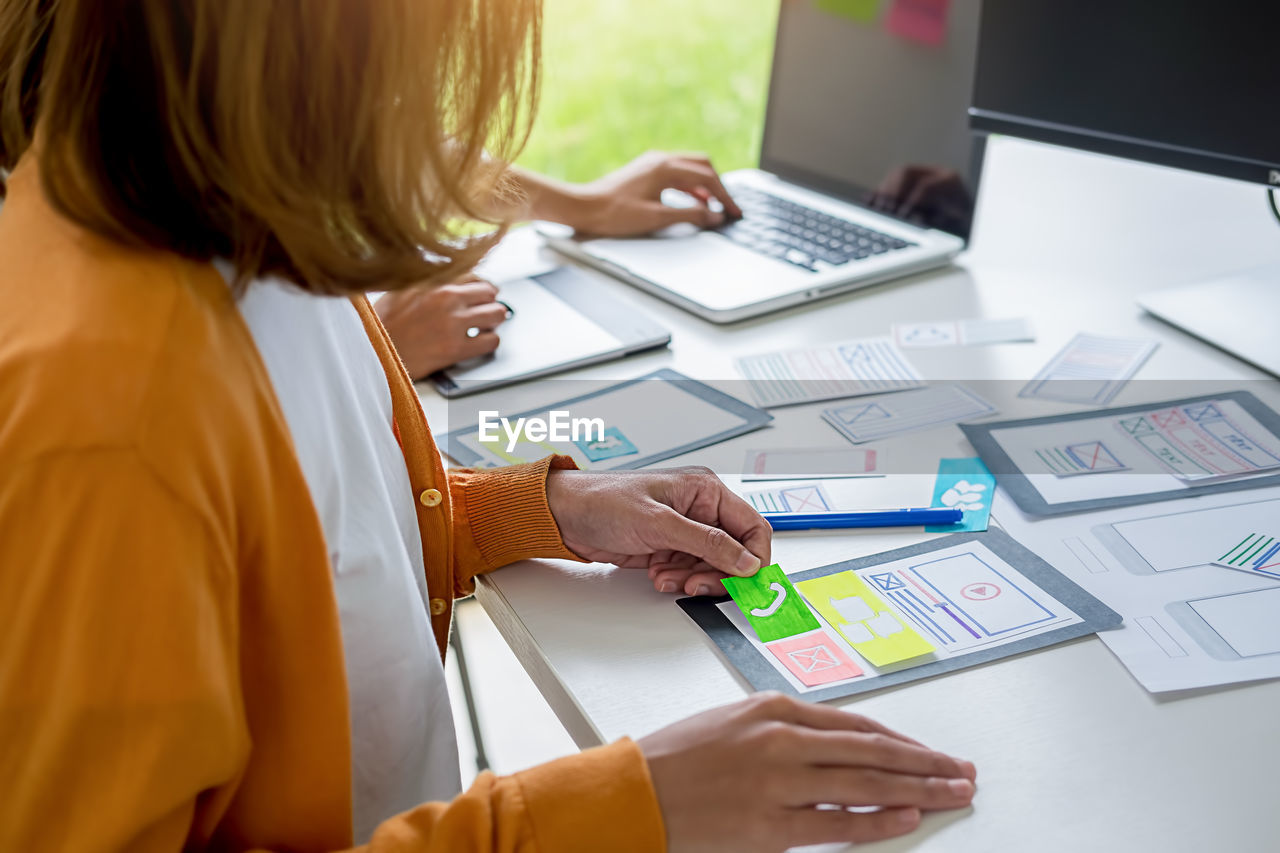 Midsection of businesswoman working at desk