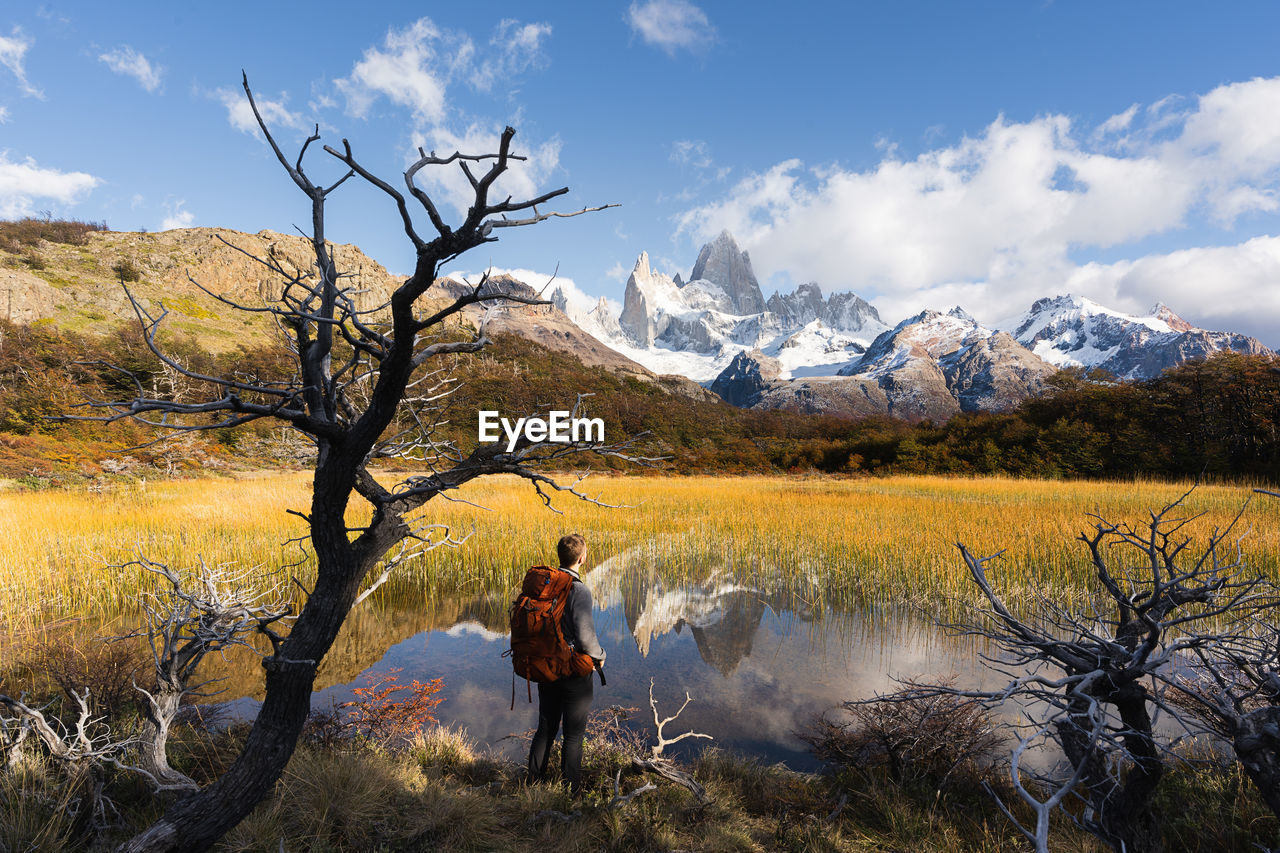 Man standing by lake against sky