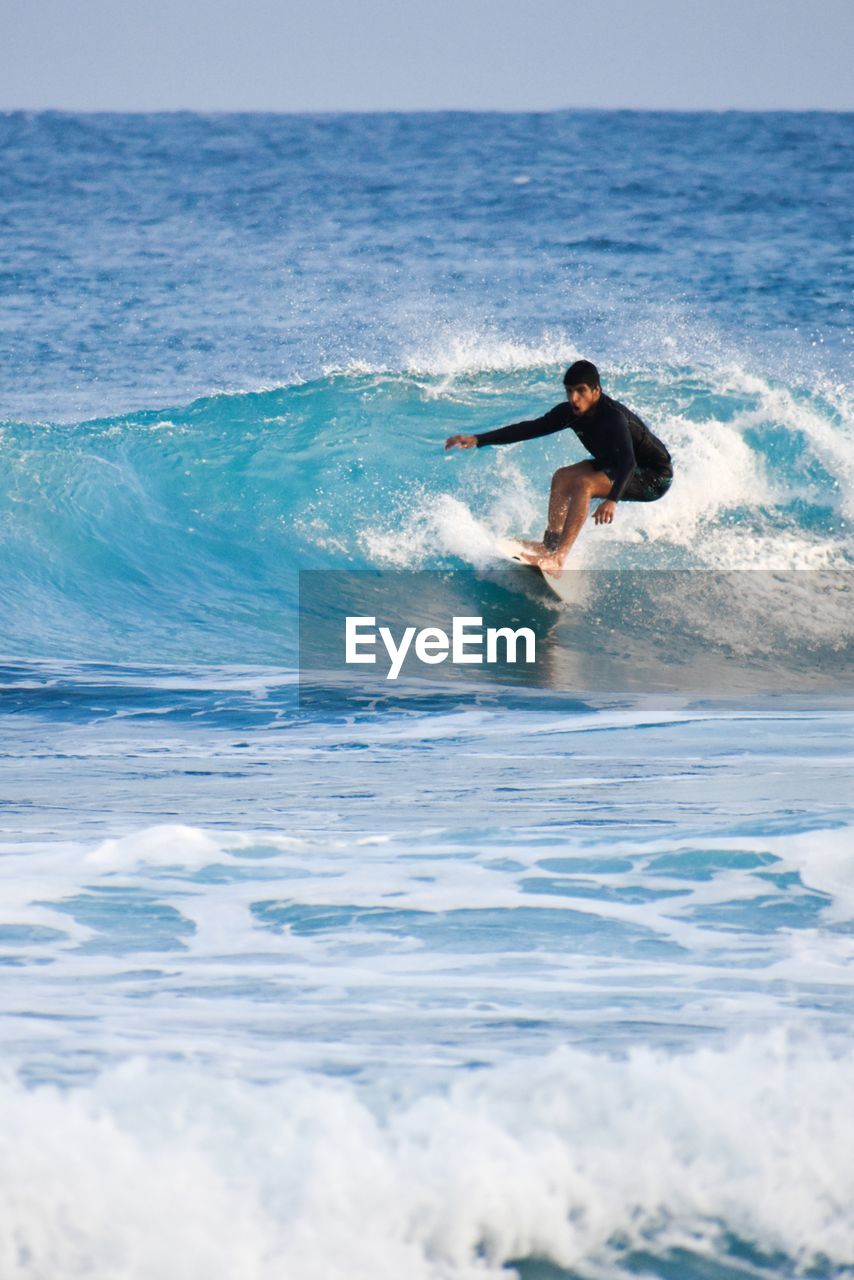 rear view of man surfing in sea