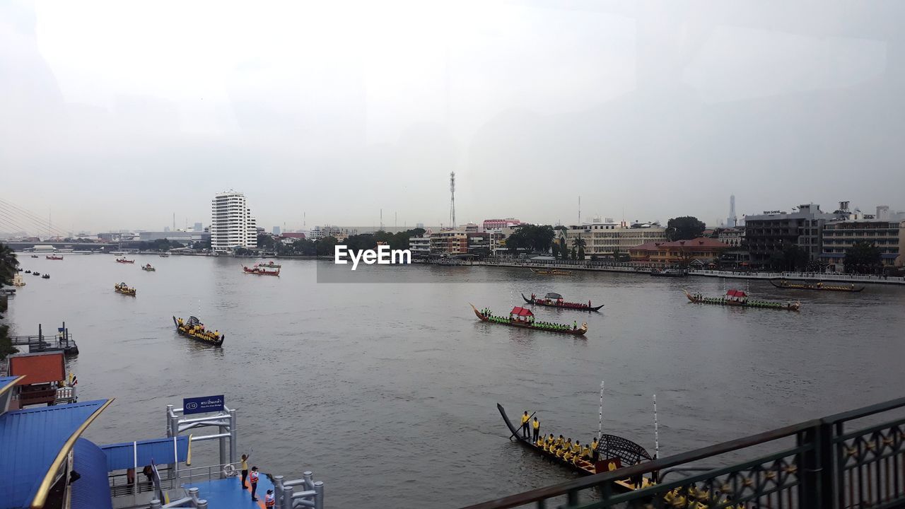 HIGH ANGLE VIEW OF RIVER BY CITYSCAPE AGAINST SKY