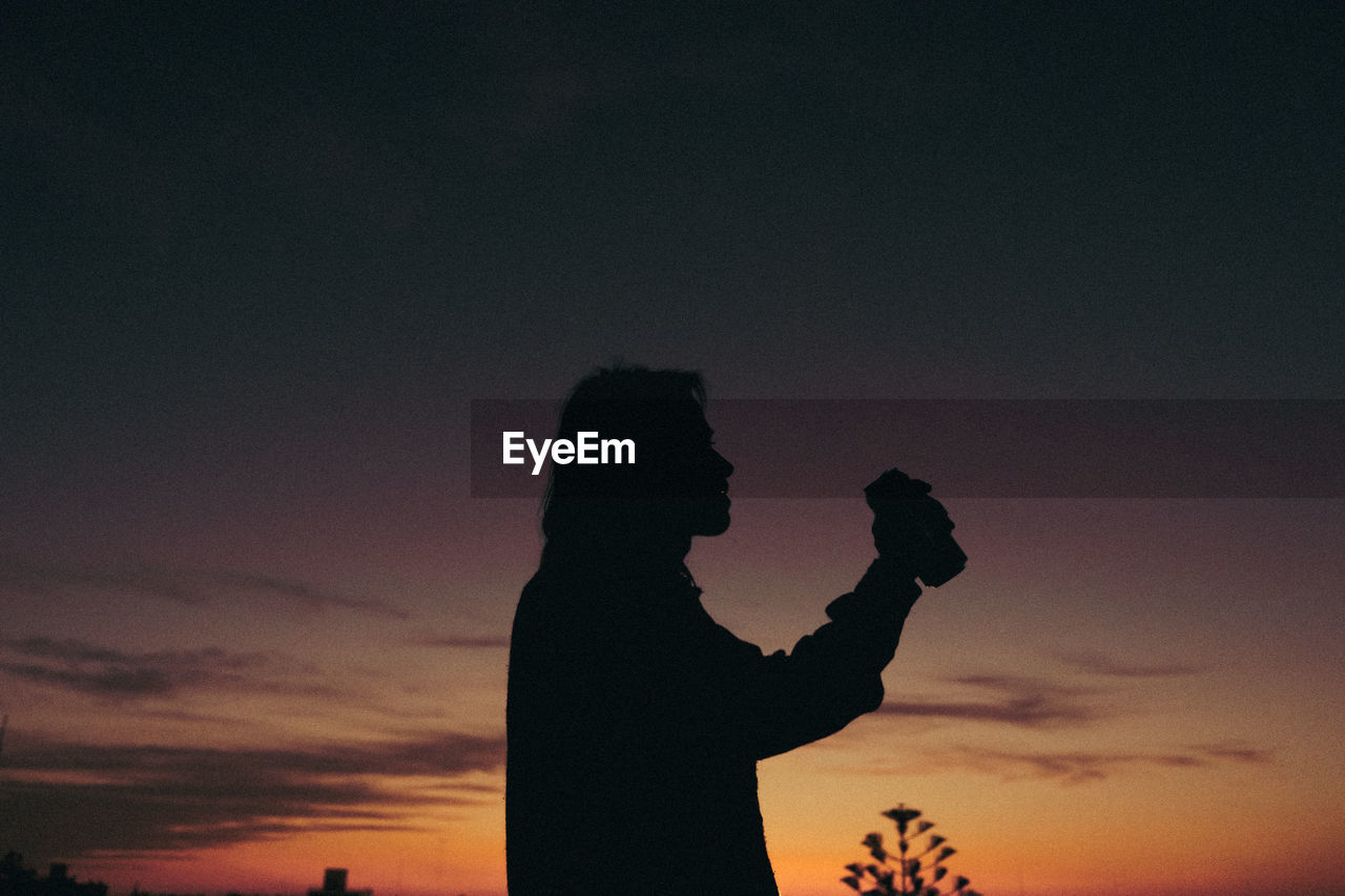 Man drinking a beer durning sunset