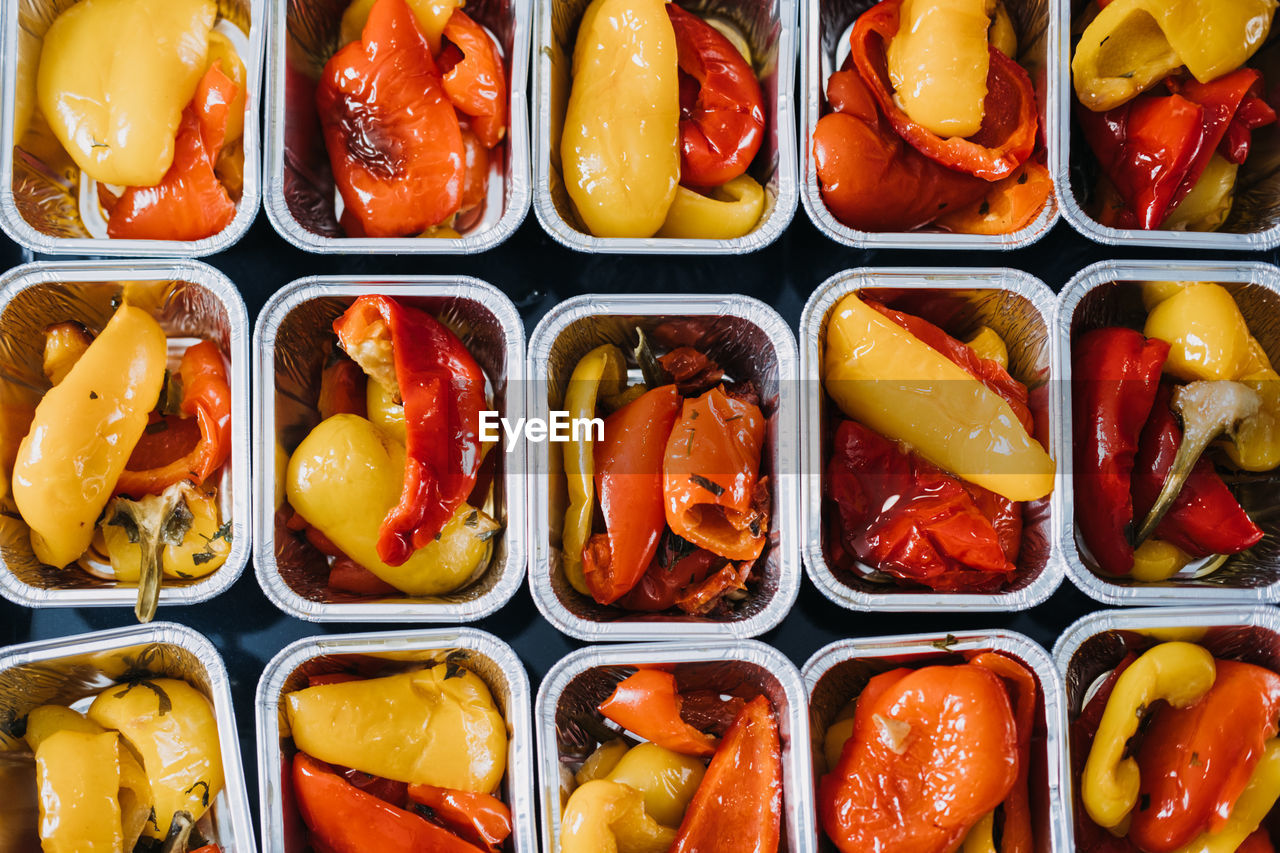 Pre-portioned gourmet roasted bell peppers in trays. close-up view of vibrant roasted bell 