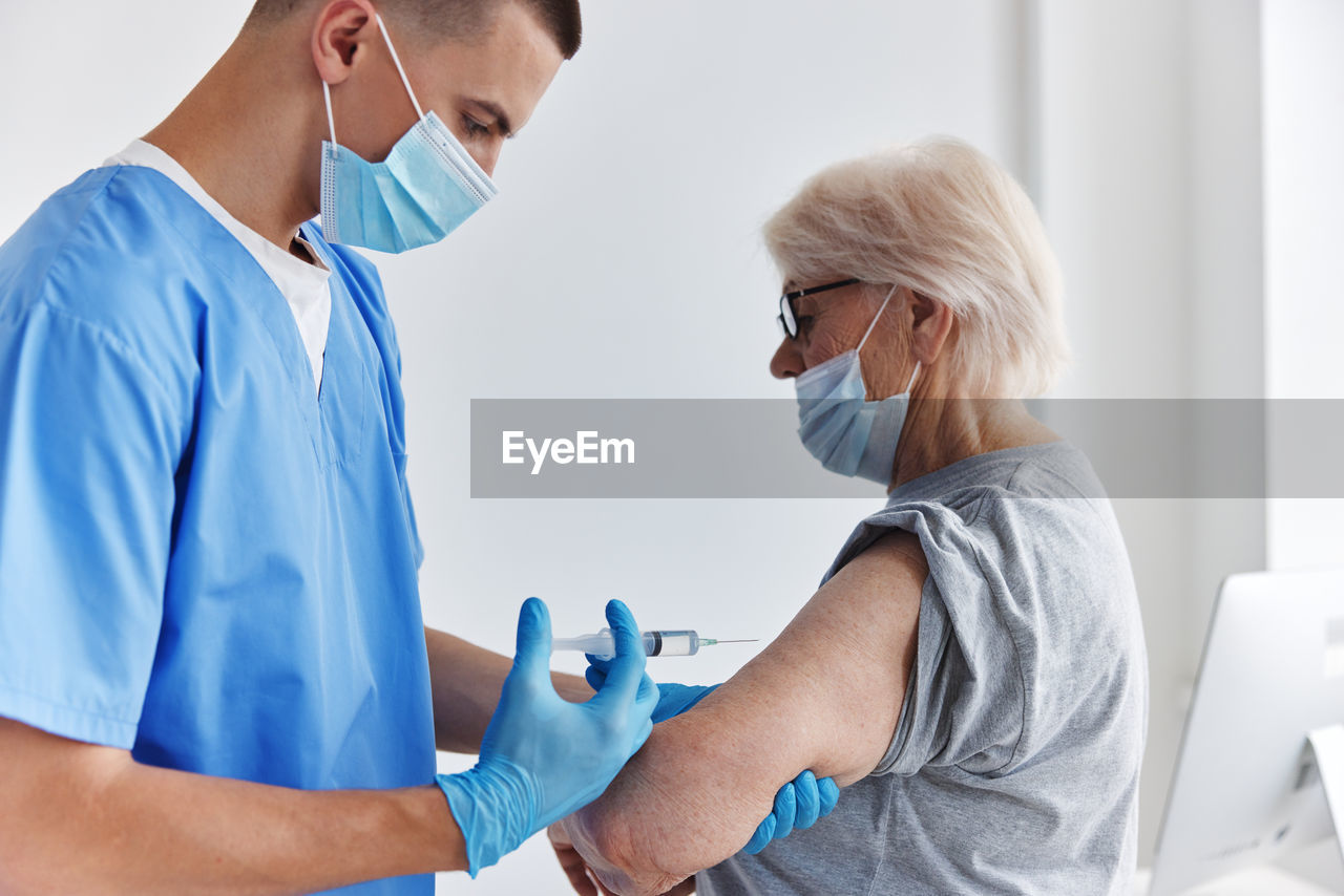 Rear view of doctor examining patient in hospital