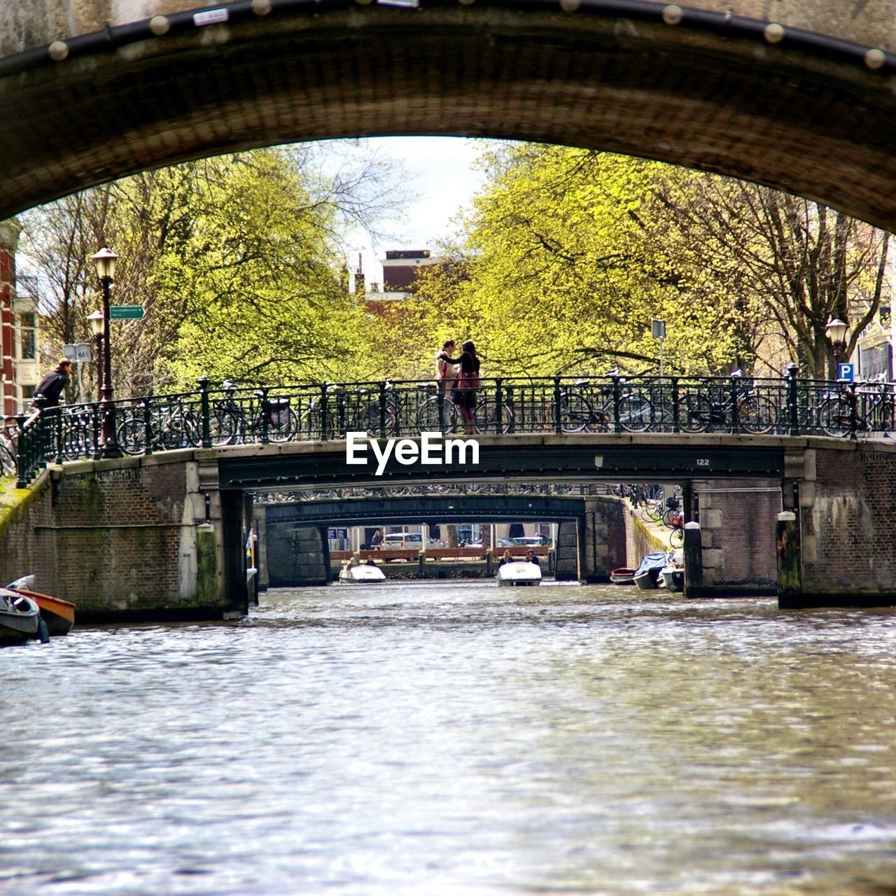 BRIDGE OVER RIVER WITH BUILDINGS IN BACKGROUND