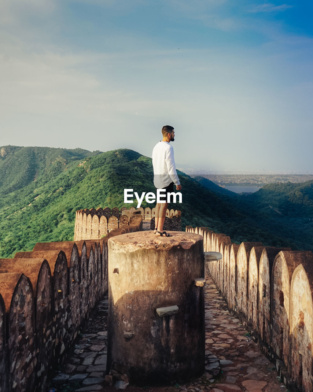 Side view of man standing on wall