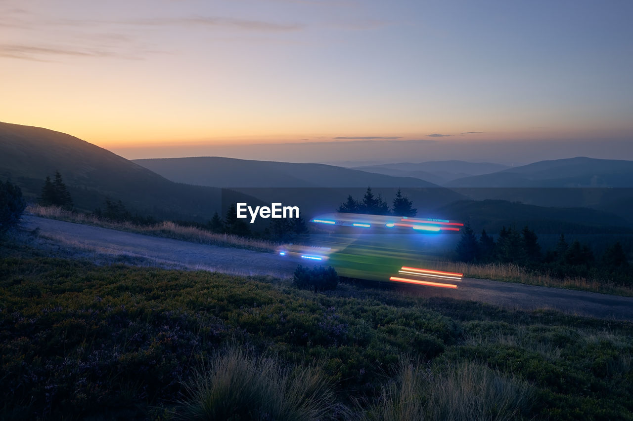 Light trails of ambulance car of emergency medical service on mountain road at night. 