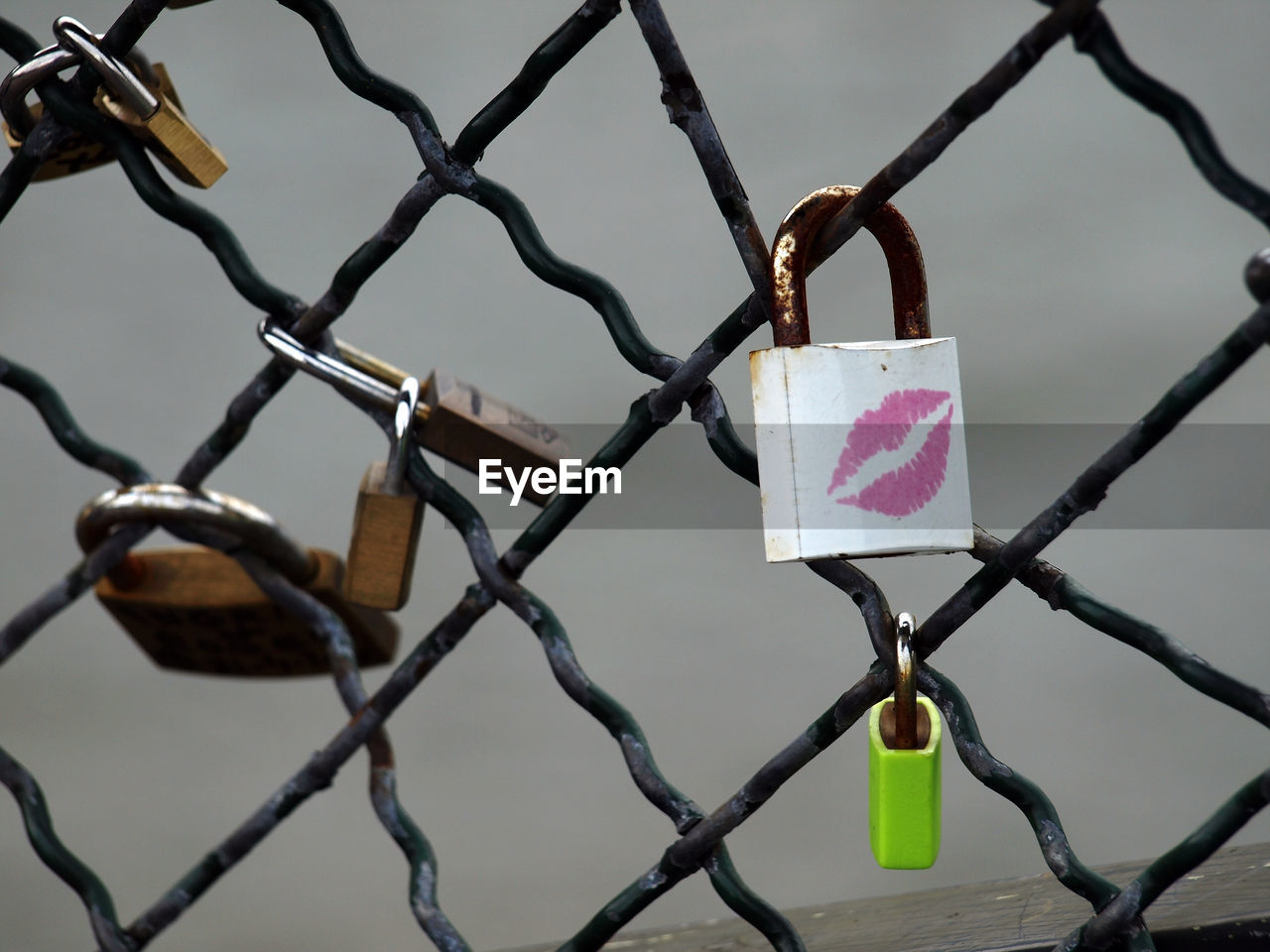 Padlocks with lipstick kiss attached on fence