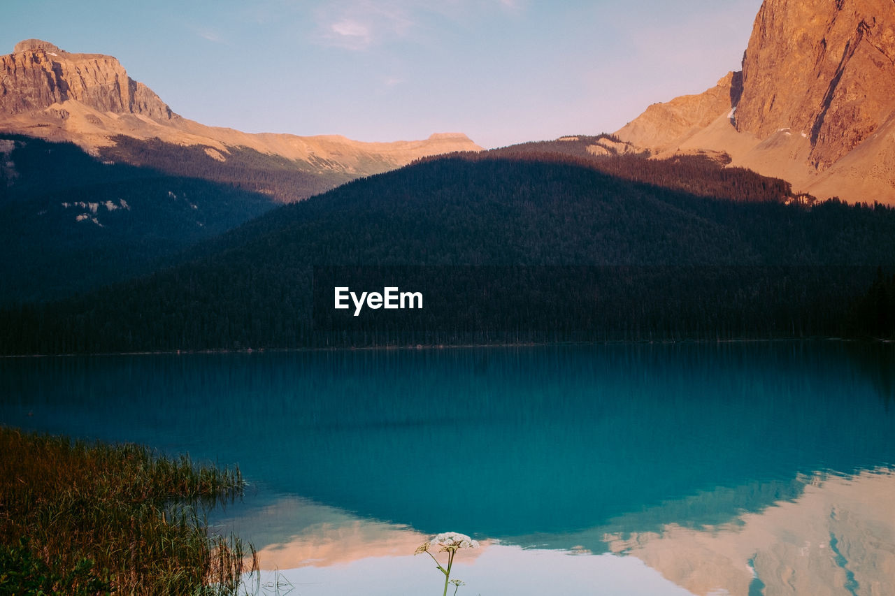 SCENIC VIEW OF LAKE BY MOUNTAIN AGAINST SKY