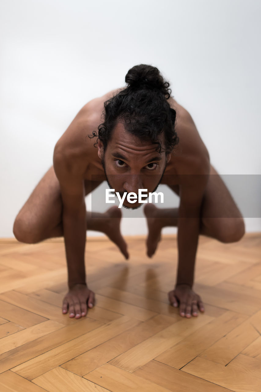 Portrait of man standing on his arms on floor practicing yoga