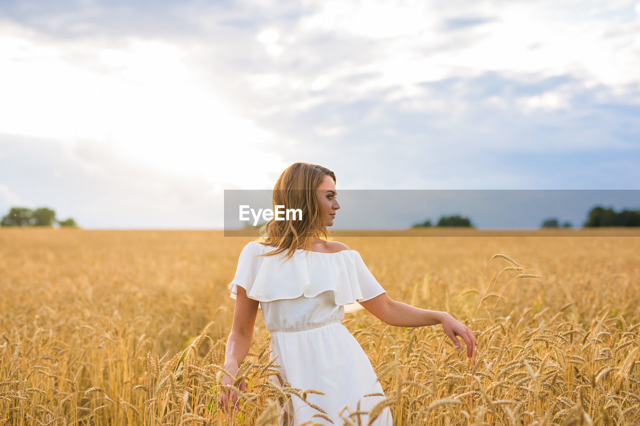 FULL LENGTH OF WOMAN STANDING IN FIELD