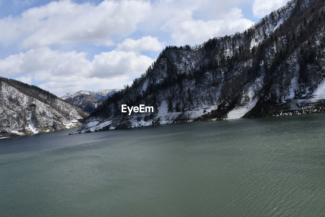 SCENIC VIEW OF MOUNTAINS AND SEA AGAINST SKY