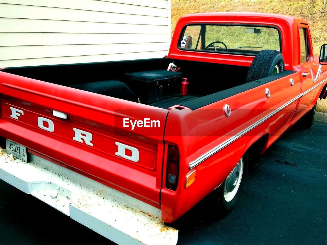 CLOSE-UP OF RED VINTAGE CAR ON BUS