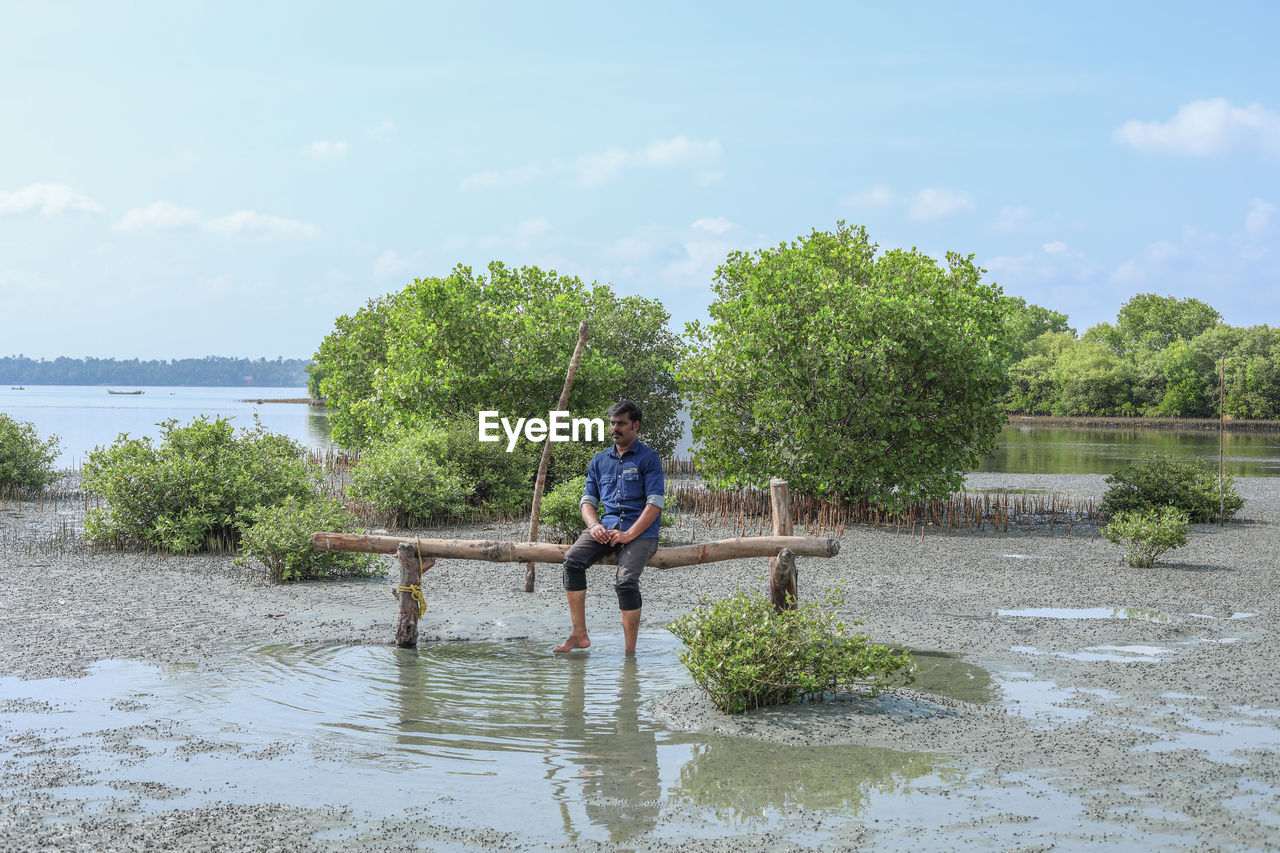 water, plant, tree, one person, nature, full length, sky, river, day, men, leisure activity, cloud, casual clothing, lifestyles, outdoors, adult, beauty in nature, childhood, growth, front view, child, standing, motion, green, waterfront, waterway