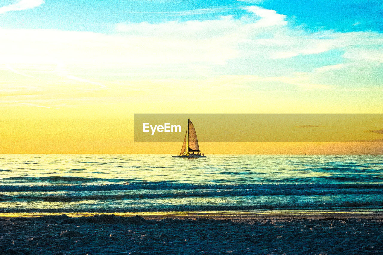 SAILBOAT SAILING ON SEA AGAINST SKY AT SUNSET