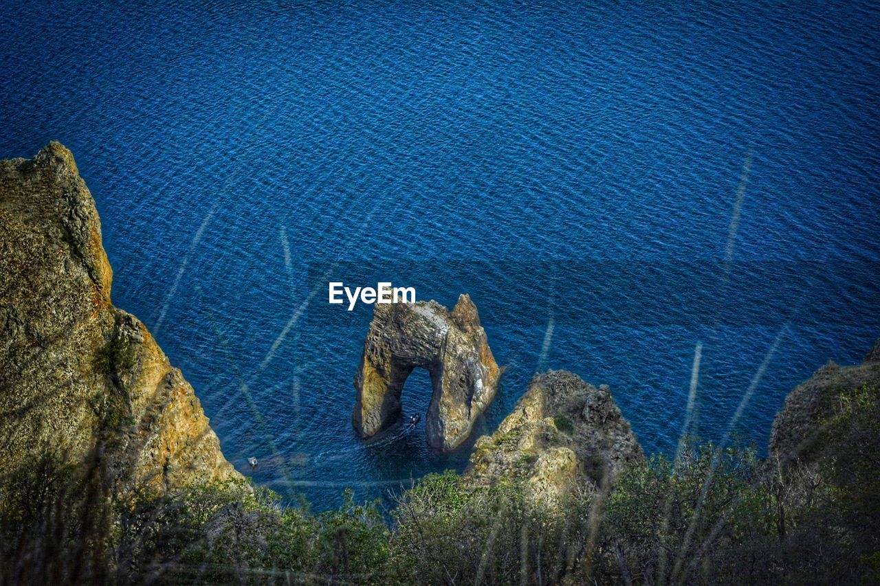 HIGH ANGLE VIEW OF ROCKS BY SEA