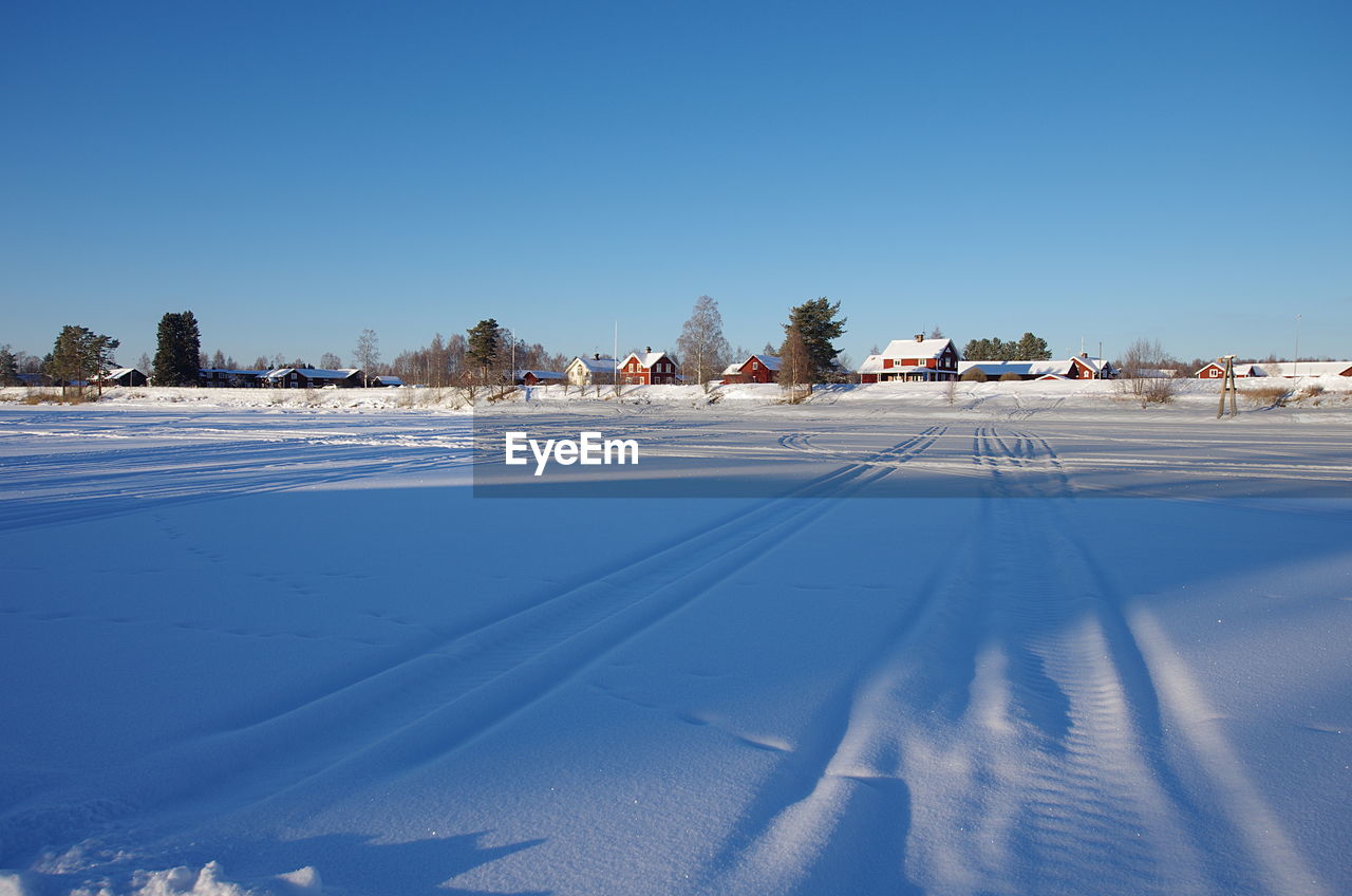 Snow covered city against clear blue sky