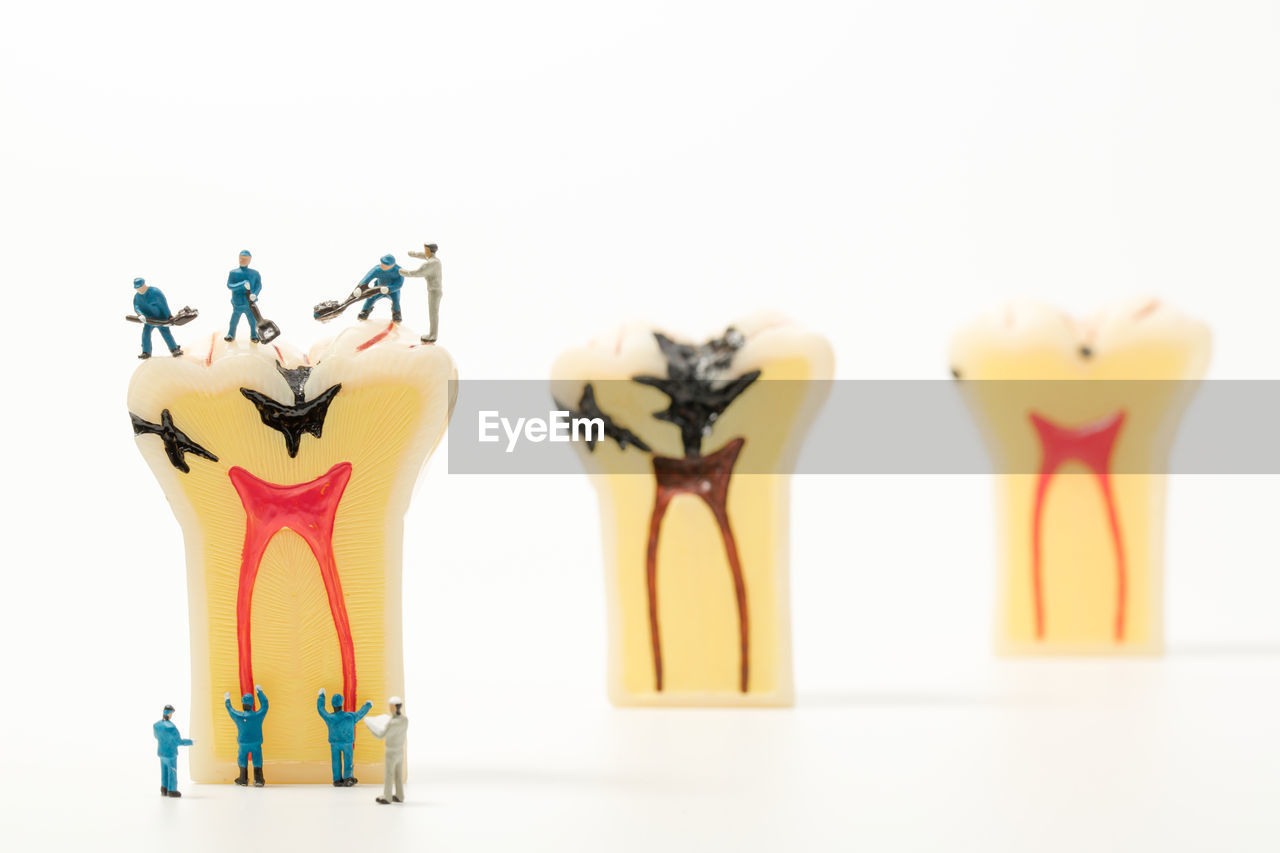 Figurines and dental equipment on white background