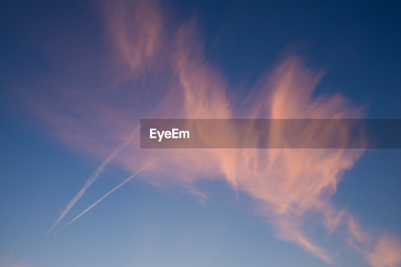 Low angle view of vapor trail in blue sky