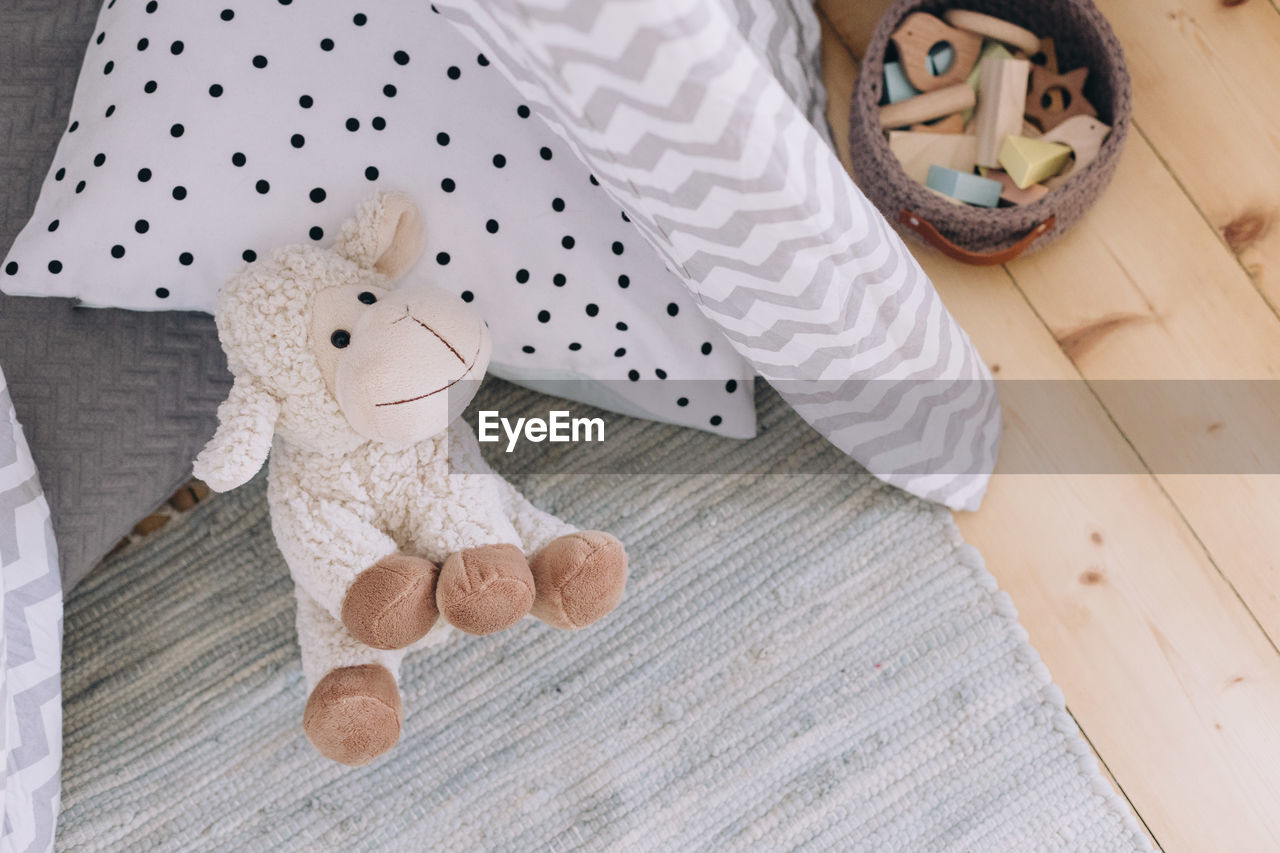 Stuffed sheep sitting in a children's play teepee, high angle view