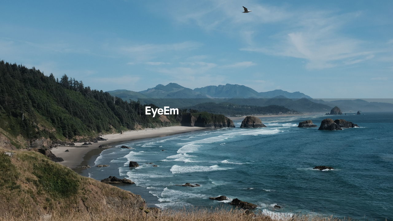 Scenic view of sea and mountains against sky