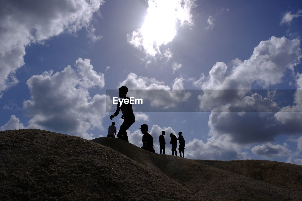 PEOPLE WALKING ON STREET AGAINST SKY