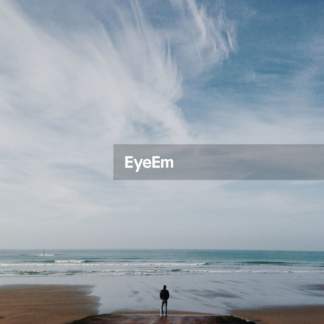 Man standing at beach against sky