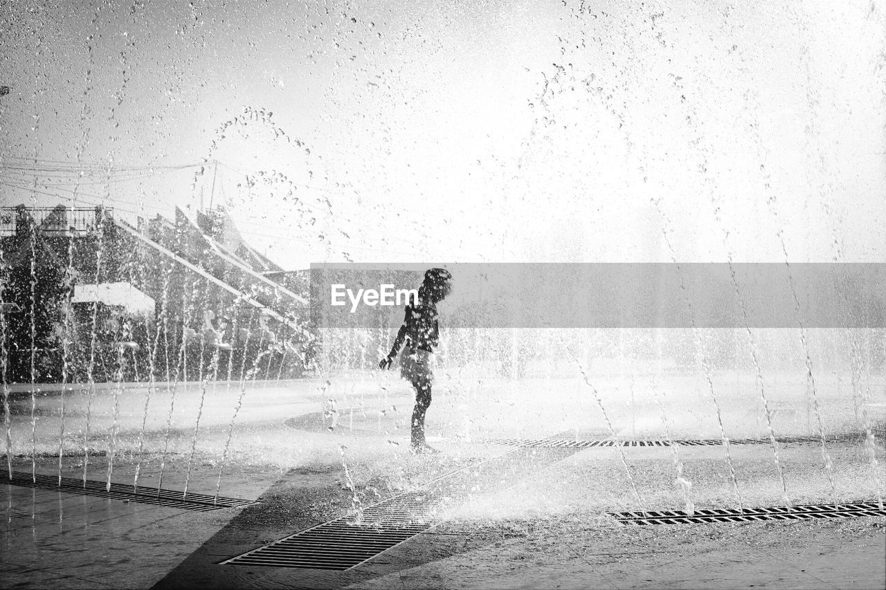 View of girl playing in fountain