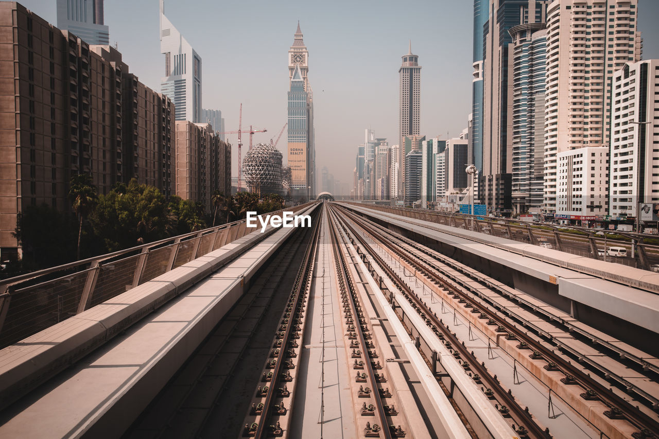 RAILROAD TRACKS IN CITY AGAINST SKY