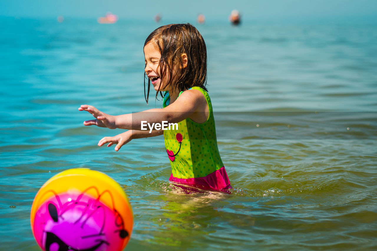 Girl playing with ball at beach