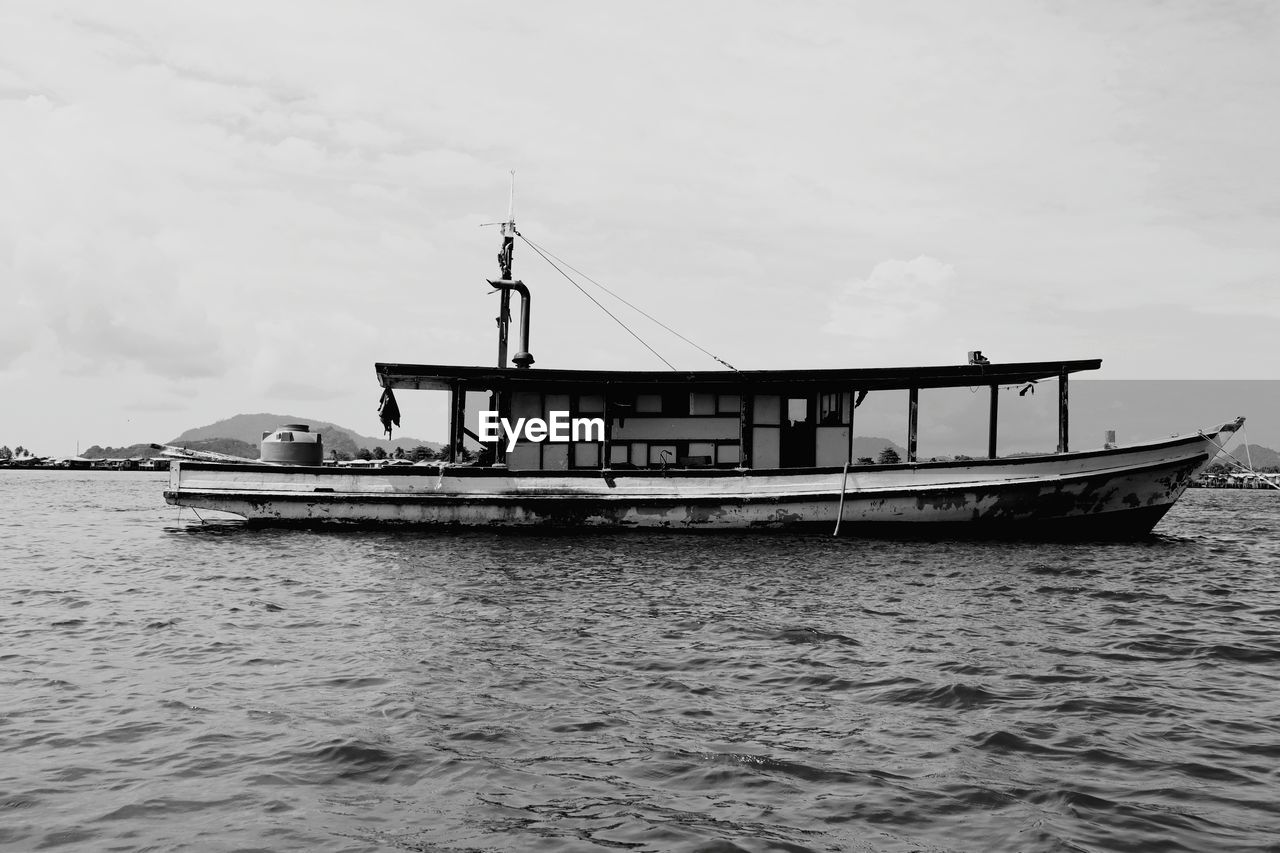 Boat sailing in sea against sky