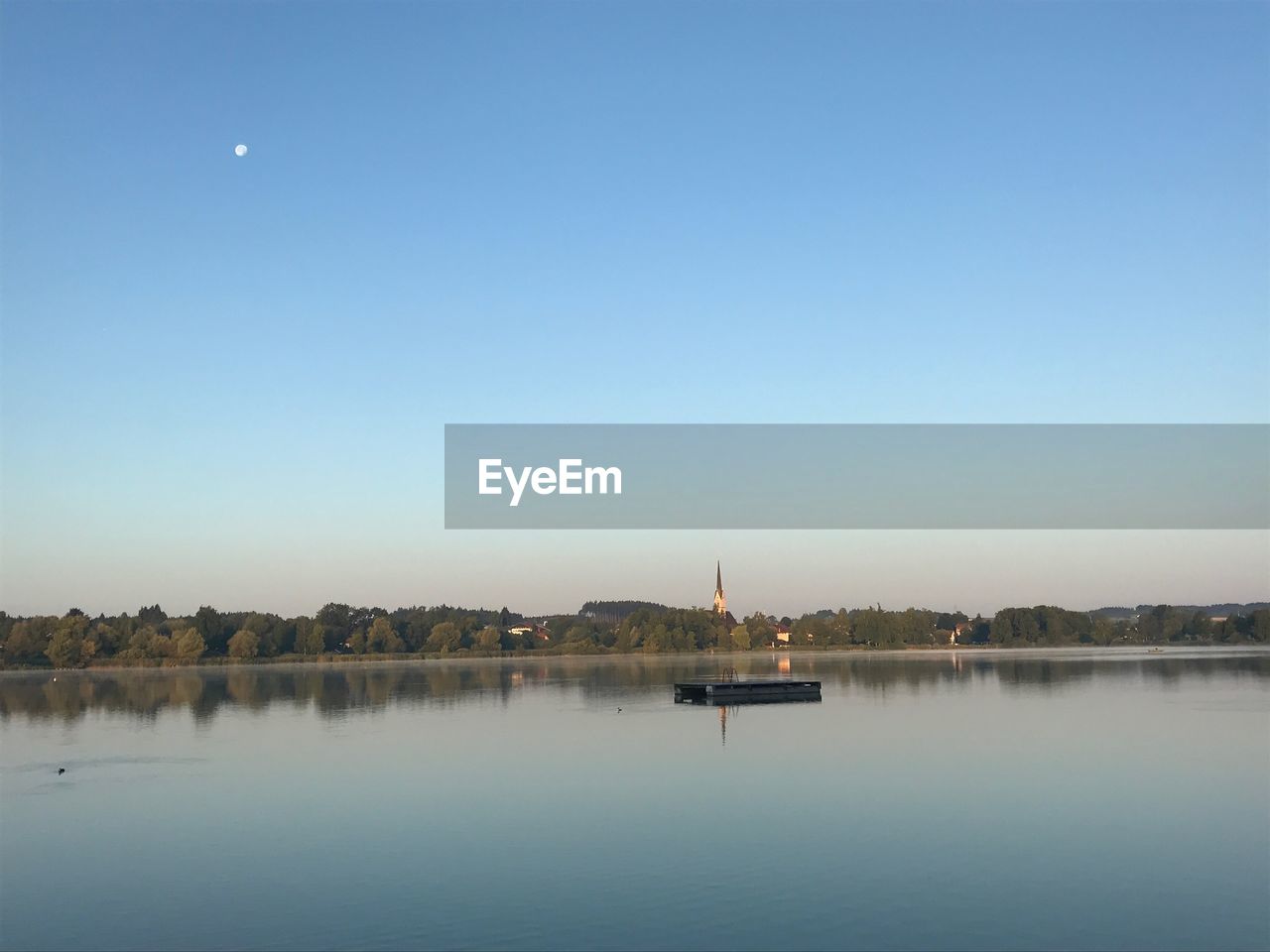 BOAT IN LAKE AGAINST CLEAR BLUE SKY