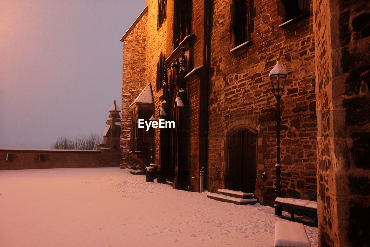 SNOW COVERED BUILDING AGAINST SKY