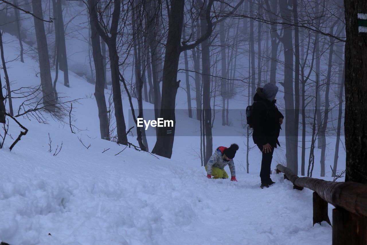 PEOPLE SKIING ON SNOW COVERED LAND