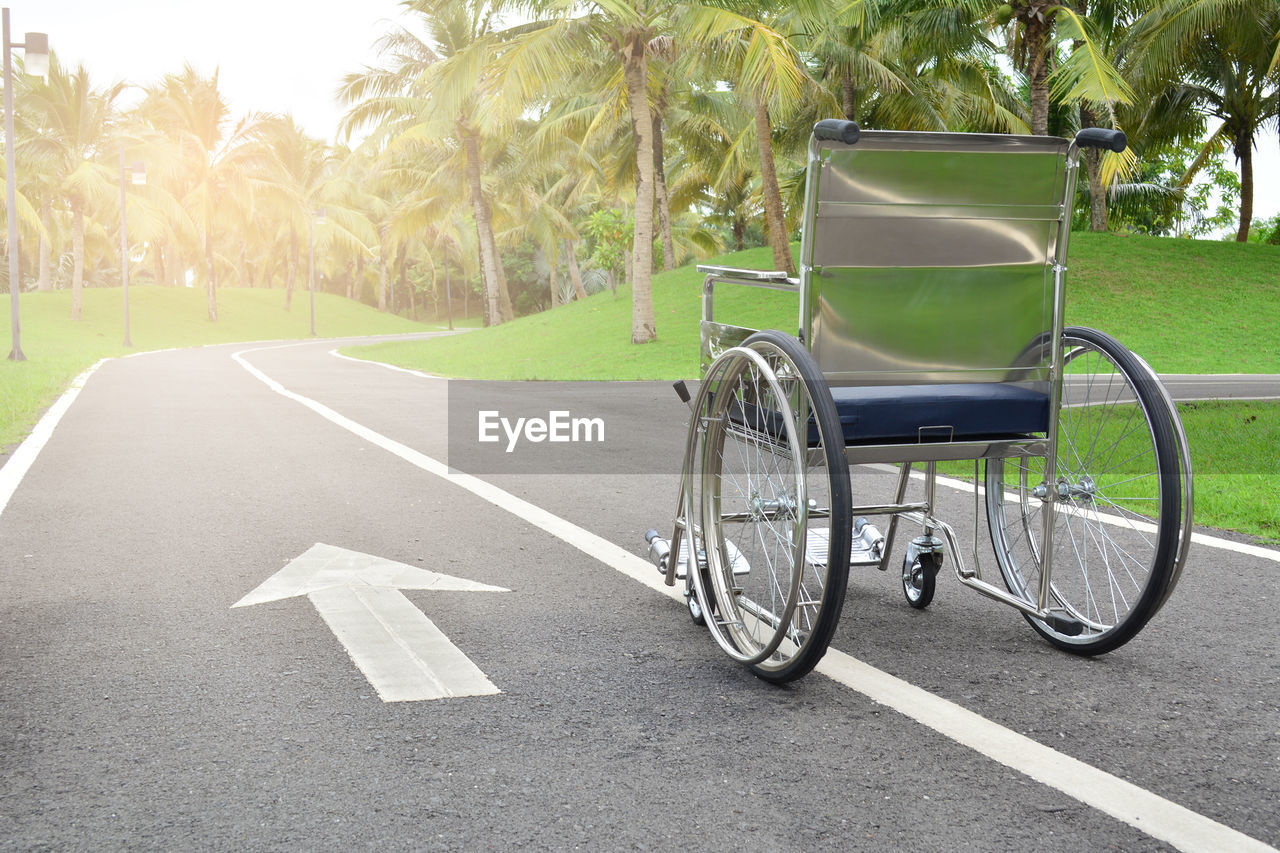 Empty wheelchair on road with arrow symbol