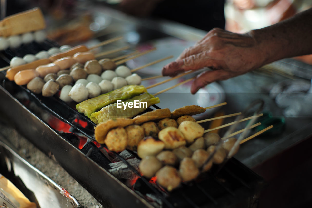 Closeup various types of balls and sausages grilled by the charcoal. street food
