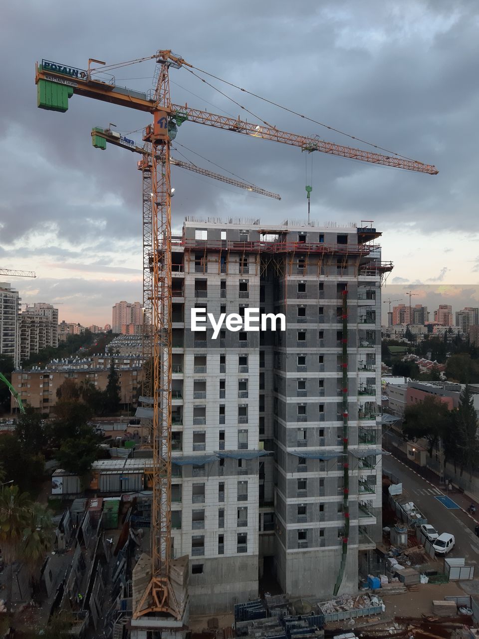 Construction site by buildings against sky in city