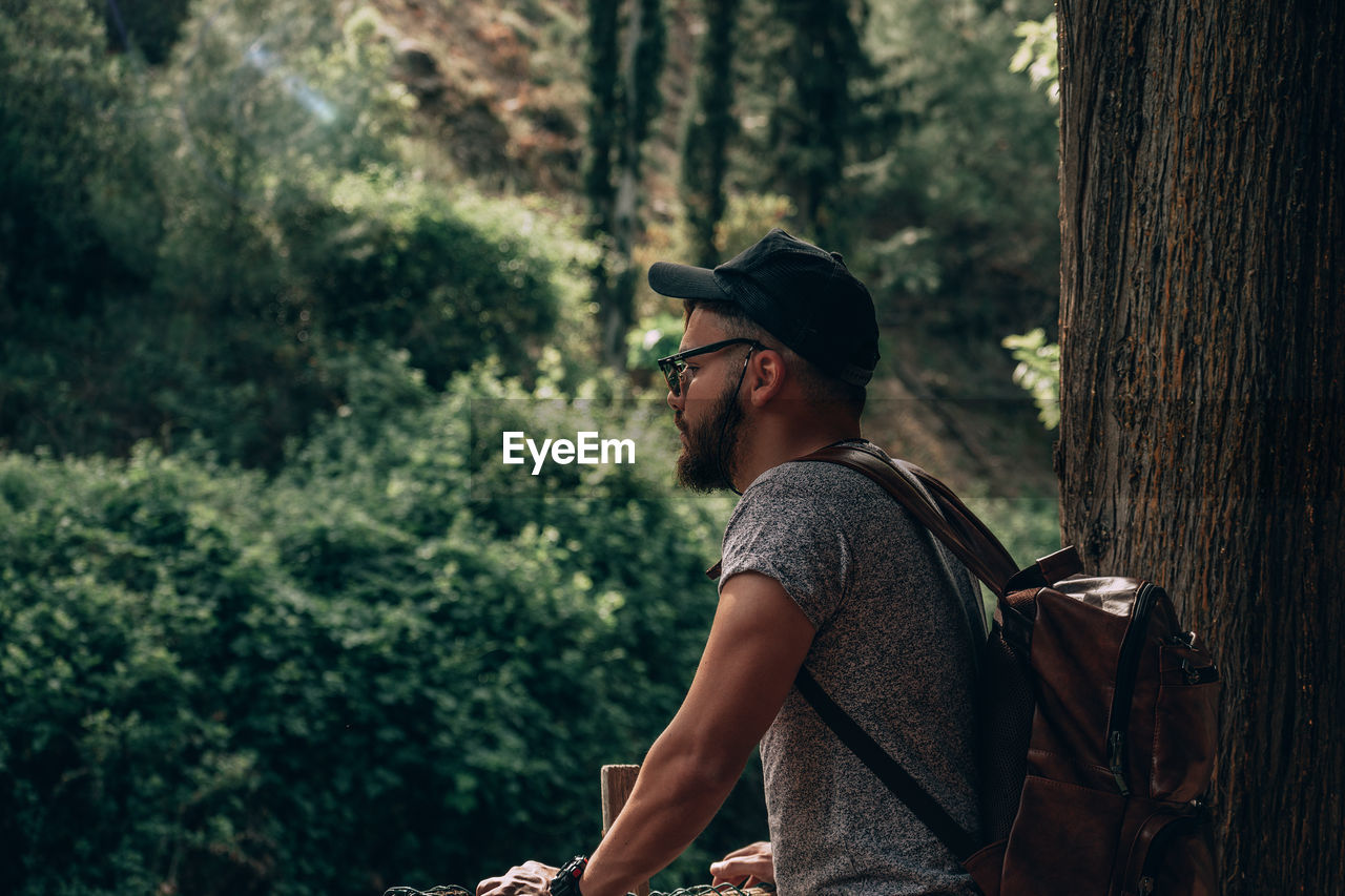 Side view of young man in forest