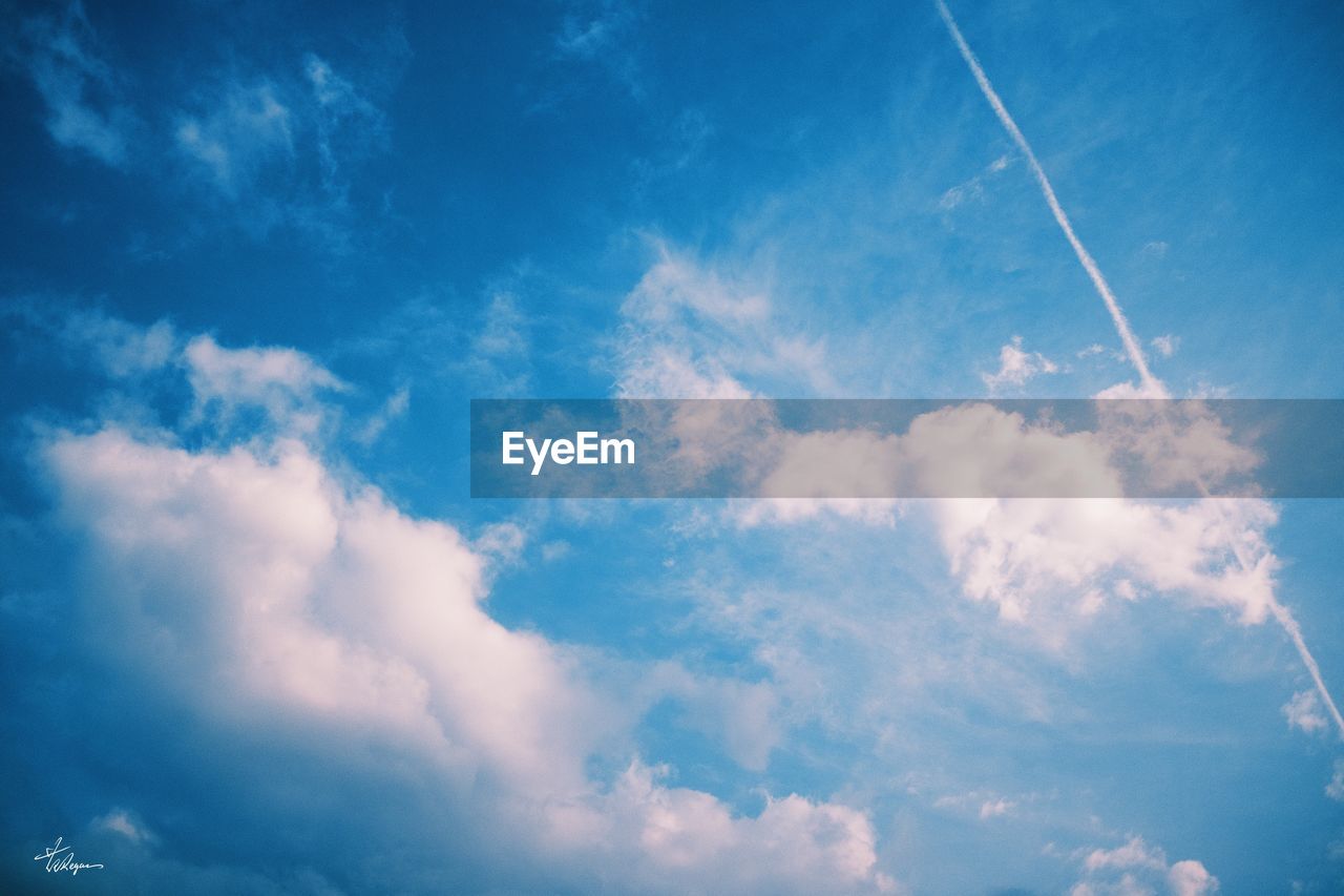 LOW ANGLE VIEW OF VAPOR TRAILS IN SKY