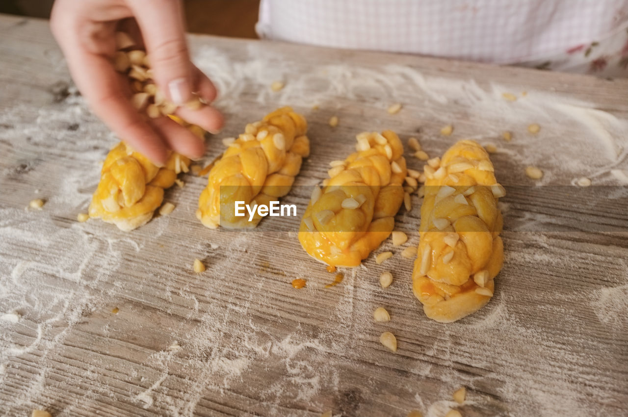 Cropped image of hand making breads on table