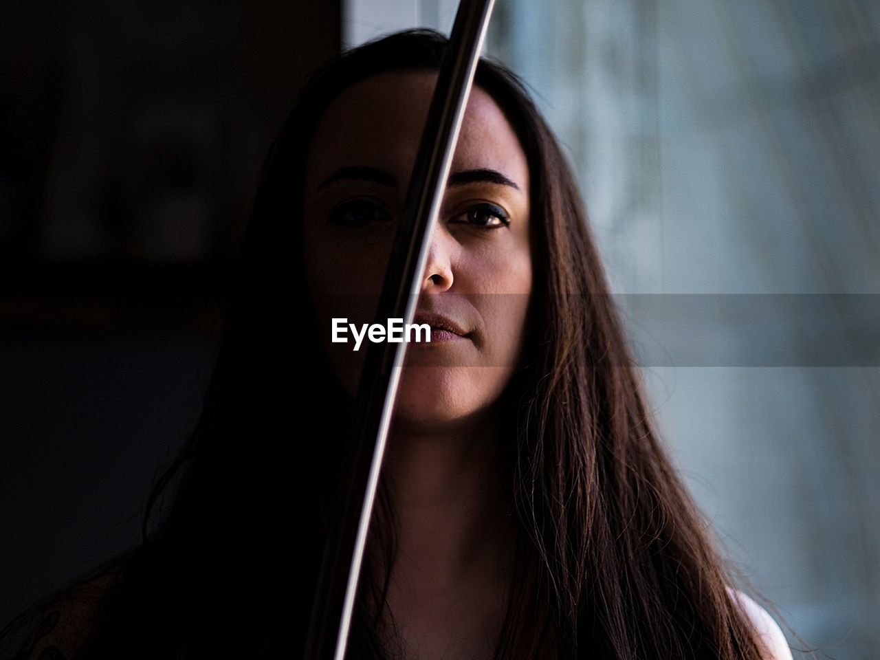 Portrait of young woman by metal rod at home