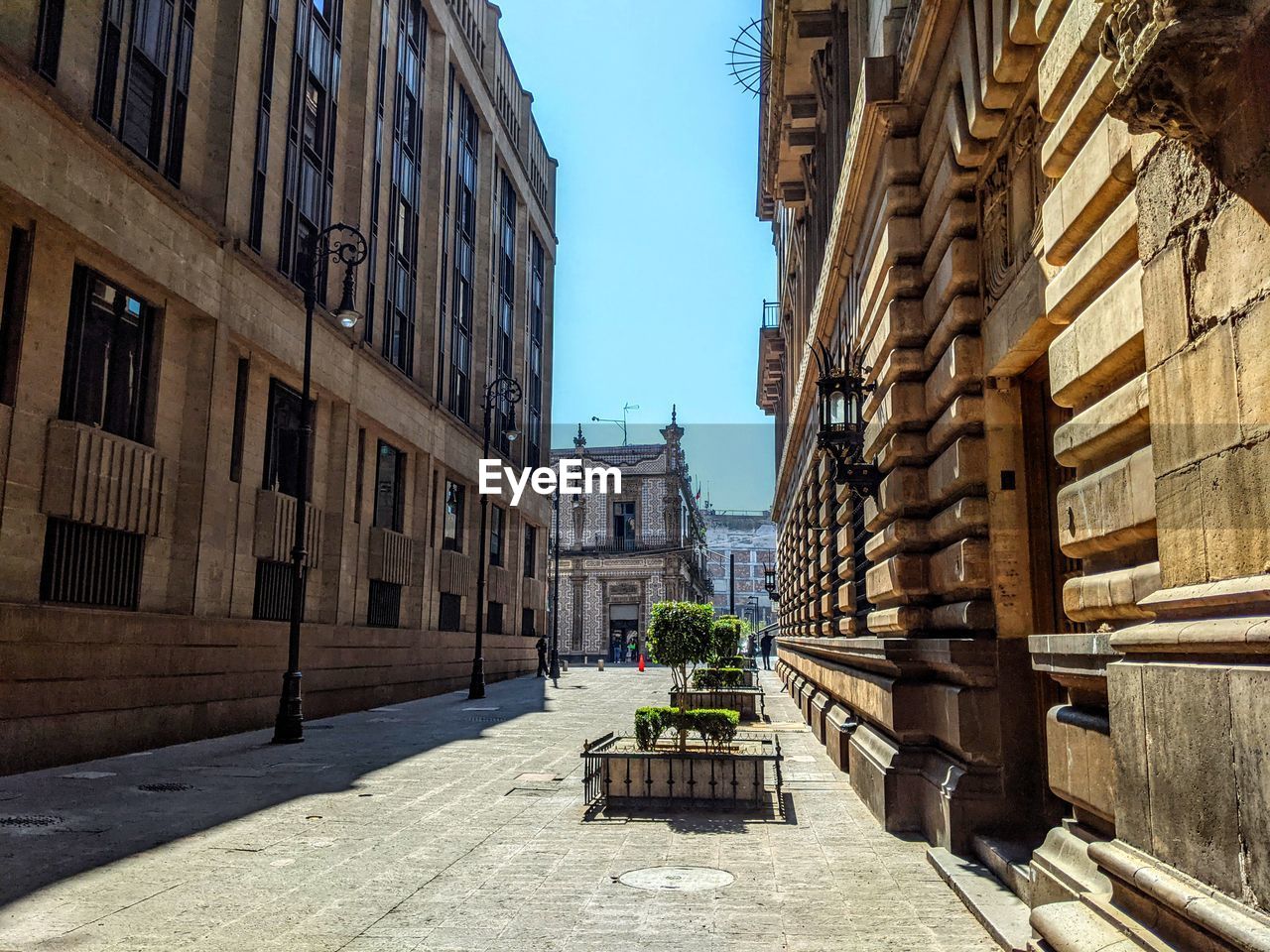 Footpath amidst buildings against sky