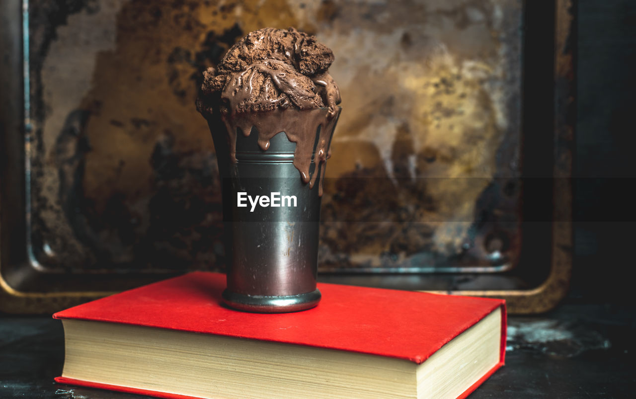 CLOSE-UP OF OPEN BOOK ON TABLE IN OLD KITCHEN