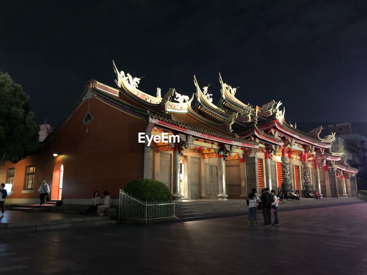 People standing in front of historical building at night