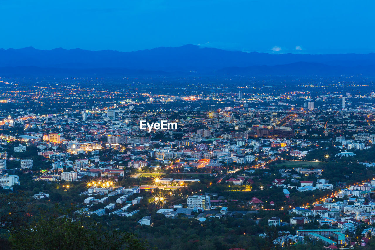 High angle view of illuminated cityscape against sky at dusk